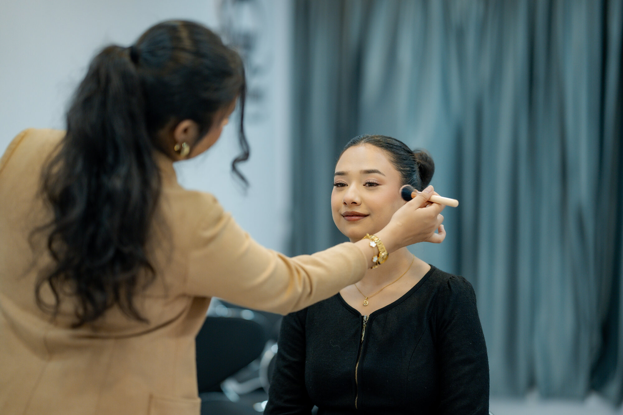 Shristi applying makeup to a client at the studio